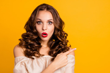 Close-up portrait of her she nice attractive lovely charming winsome stunning amazed wavy-haired lady showing forefinger aside advert sale discount isolated over bright vivid shine yellow background