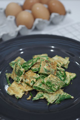 Warm Fried Eggs with Climbing Wattle in Black Dish