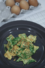 Warm Fried Eggs with Climbing Wattle in Black Dish