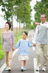 一本道で手をつなぐ祖父母と孫