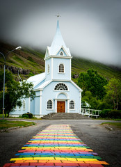 White church with rainbow path in Iceland