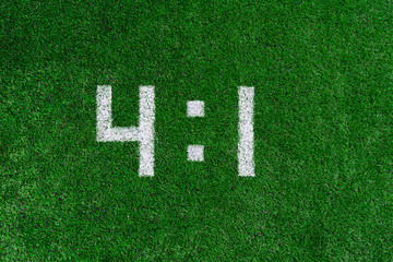Football score.White numbers four and one are drawn on the green grass,creative scoreboard