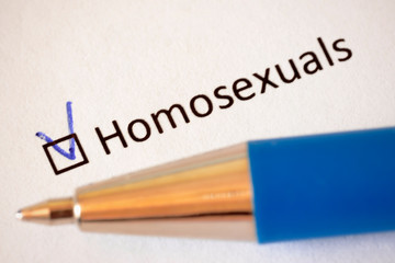 Questionnaire. Blue pen and the inscription HOMOSEXUALS with check mark on the white paper