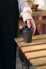 Fototapeta na wymiar Paper coffee cup ready to go or take away coffee . Girl waits drinking hot coffee to go on the street