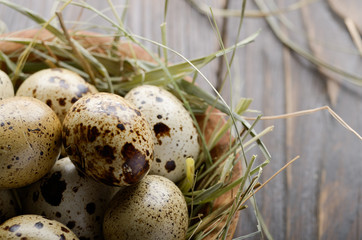 Obraz premium Fresh organic quail eggs in wooden bowl on rustic kitchen table. Space for text