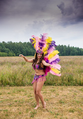 Young girl in bright colorful carnival costume posing outdoors