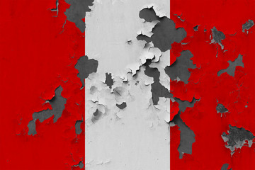 Close up grungy, damaged and weathered Peru flag on wall peeling off paint to see inside surface.