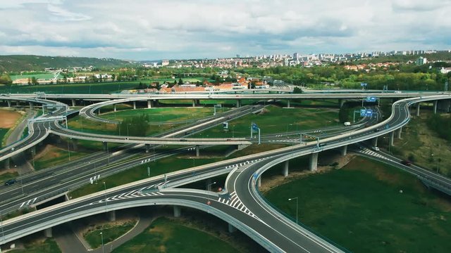 Aerial top down view on multilevel interchange overpass in Zbraslav showing afternoon traffic under sun and cloud