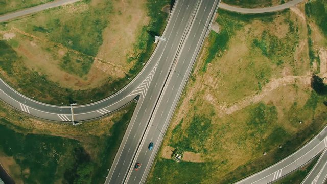Aerial top down view on multilevel interchange overpass in Zbraslav showing afternoon traffic under sun and cloud