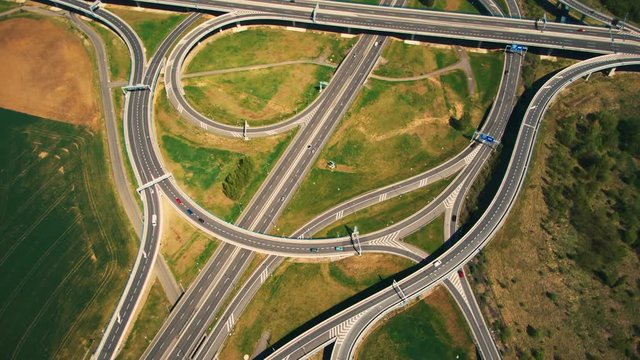 Aerial top down view on multilevel interchange overpass in Zbraslav showing afternoon traffic under sun and cloud