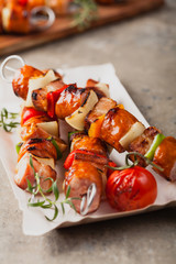 Grilled skewers with sausage, bacon and vegetables.