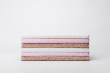 Stacked white, pink, apricot towels