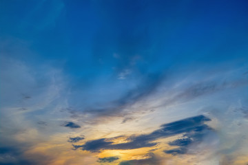 Obraz premium Blue sky with gold clouds - dramatic sunset, beautiful natural background. Setting sun illuminates the clouds.