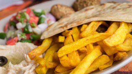 Closeup French fried with humus and pita plate