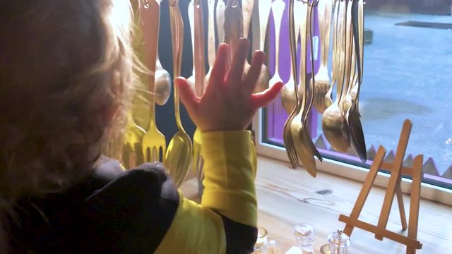 A little boy is played with decorative tableware in a cafe