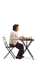 Senior woman playing chess at a table