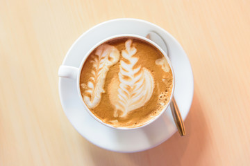 hot cappuccino coffee with nice pattern foam on table