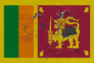 Close up grungy, damaged and weathered Sri Lanka flag on wall peeling off paint to see inside surface.