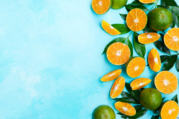 Fresh oranges on blue background. Top view. Copy space.