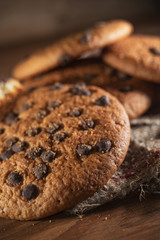 Fresh chocolate americana cookies on wooden table. Chocolate chip cookies on rural background.