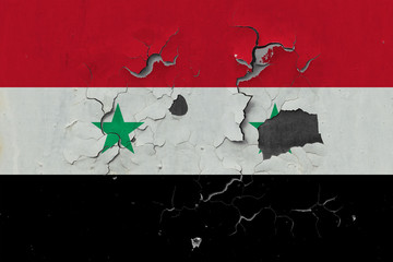 Close up grungy, damaged and weathered Syria flag on wall peeling off paint to see inside surface.