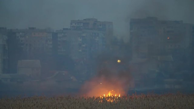 Modern buildings on the Dnipro bank and bright flame across the river at night   