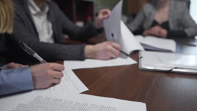 Close Up of Pencils in Hands of Caucasian Couple Signing Contract in Office. Light Camera Movement