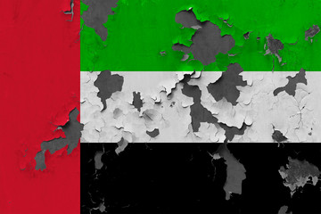 Close up grungy, damaged and weathered United Arab Emirates flag on wall peeling off paint to see inside surface.