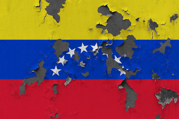 Close up grungy, damaged and weathered Venezuela flag on wall peeling off paint to see inside surface.