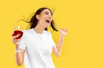 Beautiful female half-length portrait isolated on yellow studio background. Young smiling woman...
