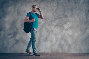 Full length side profile body size photo amazing he him his dark skin macho handsome motion go classes lessons carry rear bag wear specs casual blue t-shirt pants shoes isolated grey background