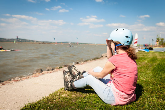Close up picture of a woman wear inline roller blades near a strand of a lake