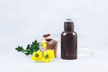 bottle of eco-friendly oil for skin care on a white background with flowers and crystal