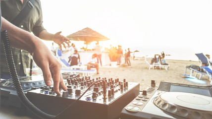 Dj mixing at sunset beach party in summer vacation outdoor - Disc jockey hands playing music for...