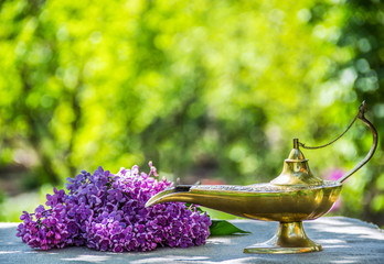 Oil lamp. Magic lamp. Genie lamp. Lilac on green background
