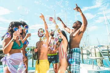 Happy friends drinking champagne in summer boat party - Young people having fun celebrating and...