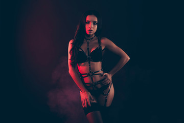 Fototapeta na wymiar Portrait of nice gorgeous attractive sporty perfect thin fit form shape line wavy-haired lady wearing swordbelt teasing enjoying lifestyle isolated on black red light background