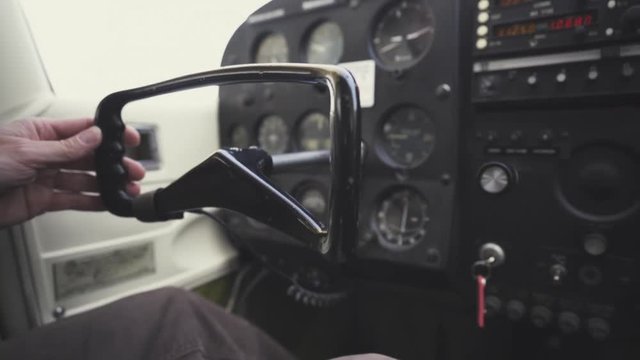 A pilot drives a plane using only one hand at the helm