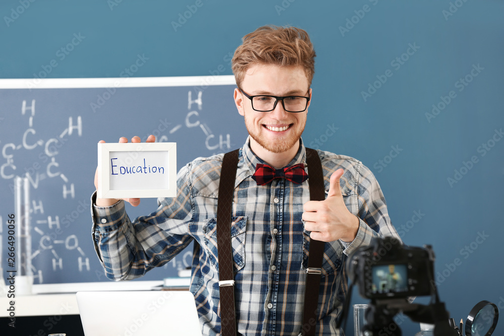 Wall mural Young male blogger recording video in laboratory