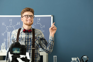 Young male blogger recording video in laboratory
