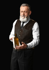 Portrait of elegant mature sommelier on dark background