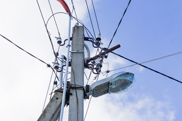 Bottom view of electric pole against blue sky.