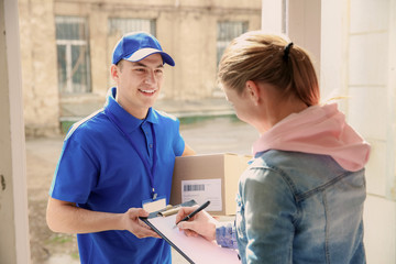 Woman signing documents to confirm receiving of order from delivery company