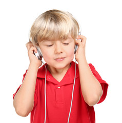 Cute little boy listening to music on white background