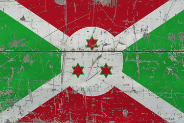 Grunge Burundi flag on old scratched wooden surface. National vintage background.