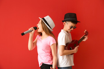 Little musicians playing against color background