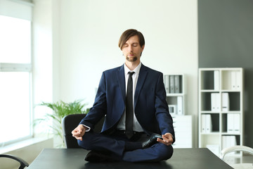 Businessman practicing yoga in office