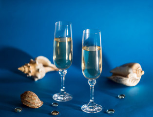Two glasses with wine on a blue background. Dream about vacation, Summer theme collage.