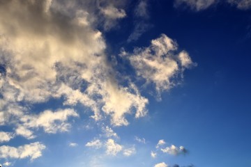 Interesting white and dark mixed cloud formations on a blue sky in spring
