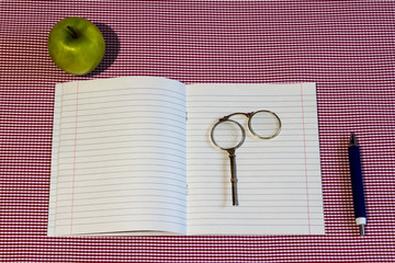 back to school. Notebook, pen, pencil, glasses pince-nez, green apple. Background pink - obrazy, fototapety, plakaty